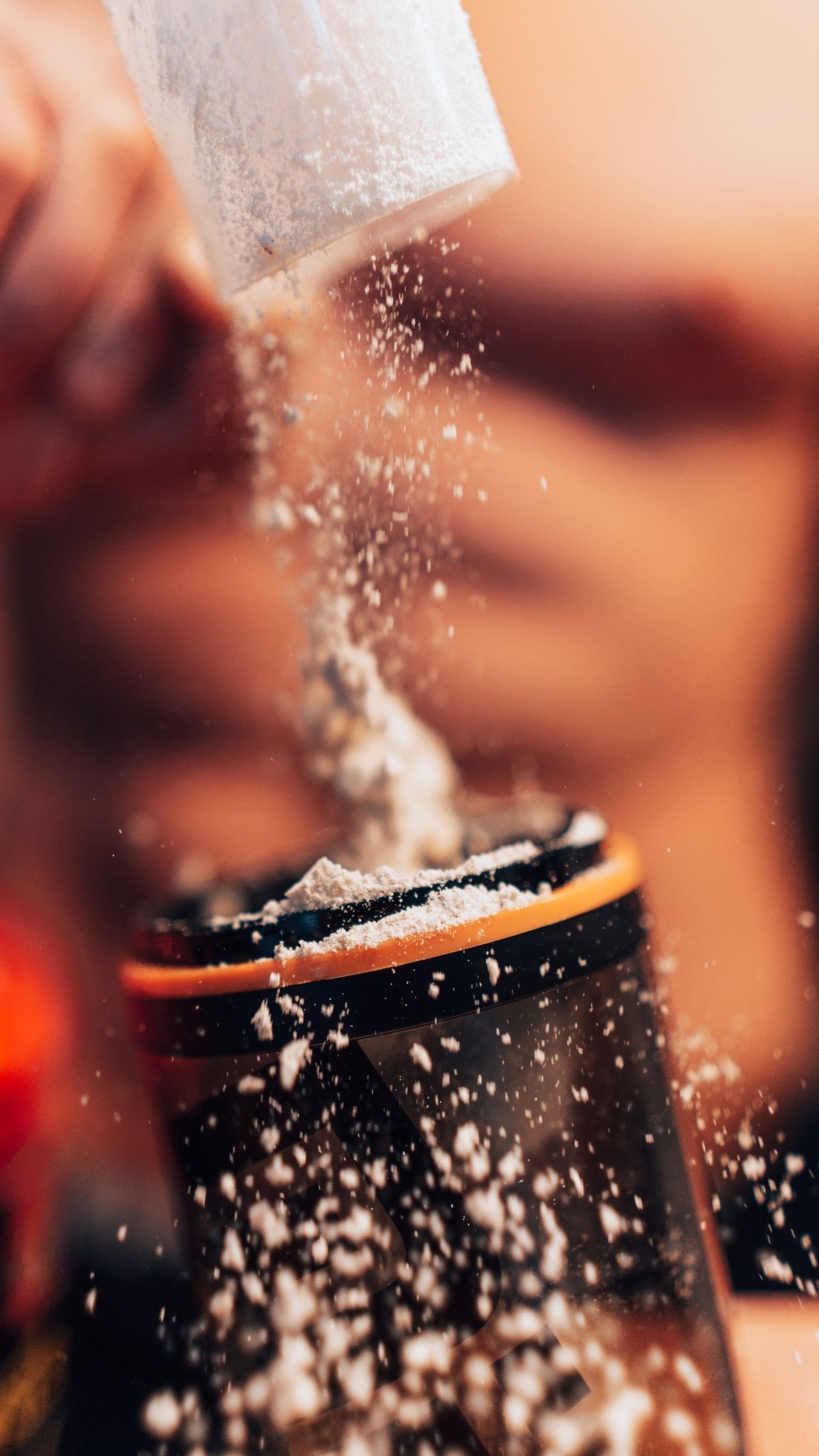 Creatine supplement powder scoop beside a shaker